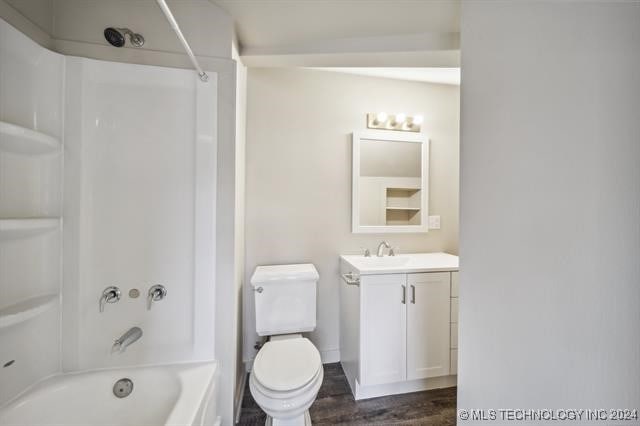 full bathroom with hardwood / wood-style flooring, toilet, vanity, and tub / shower combination