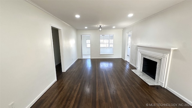 unfurnished living room with ceiling fan, a fireplace, dark wood-type flooring, and ornamental molding