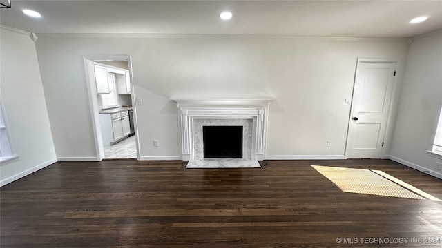 unfurnished living room featuring dark hardwood / wood-style floors, crown molding, and a fireplace