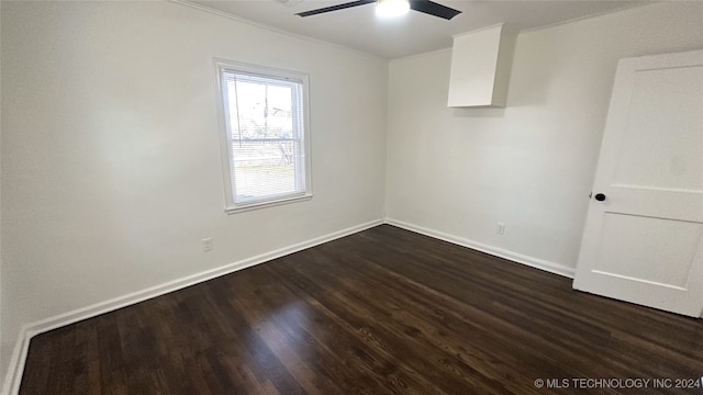 empty room featuring ceiling fan, crown molding, and dark wood-type flooring