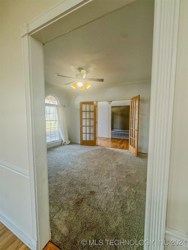 unfurnished living room featuring light carpet, french doors, and ceiling fan