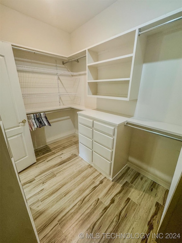 spacious closet with light hardwood / wood-style flooring