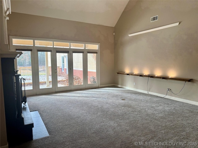 spare room featuring carpet flooring and high vaulted ceiling