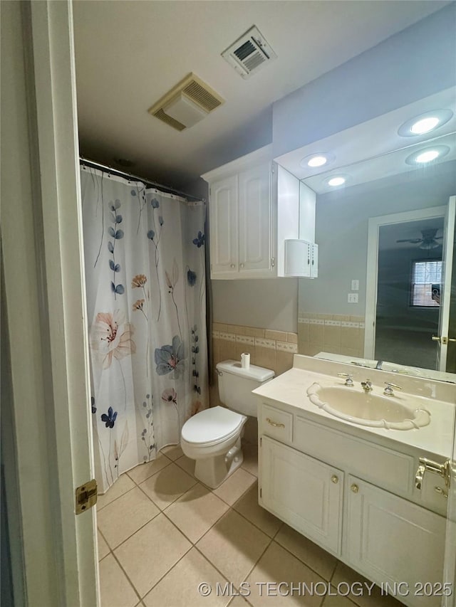 bathroom featuring vanity, tile patterned floors, a shower with shower curtain, toilet, and tile walls