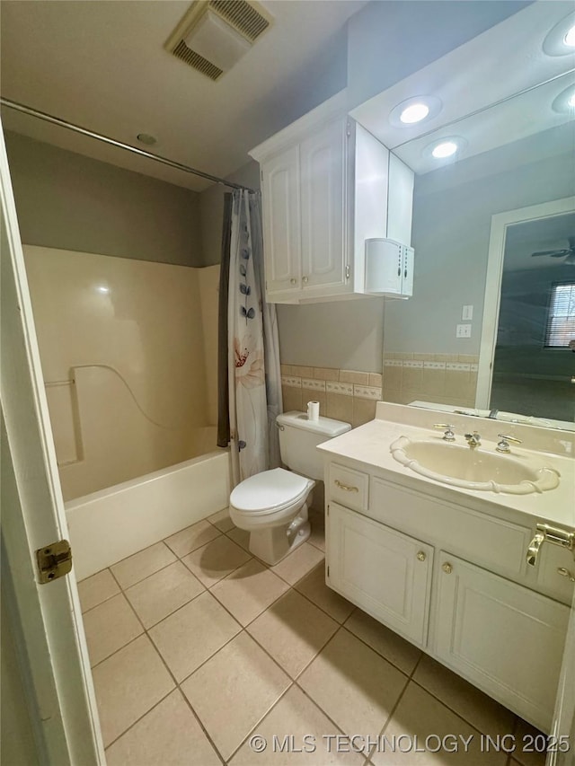 full bathroom featuring tile patterned floors, vanity, shower / bathtub combination with curtain, and tile walls