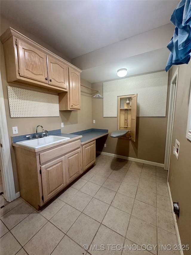 kitchen with light brown cabinets, light tile patterned floors, and sink