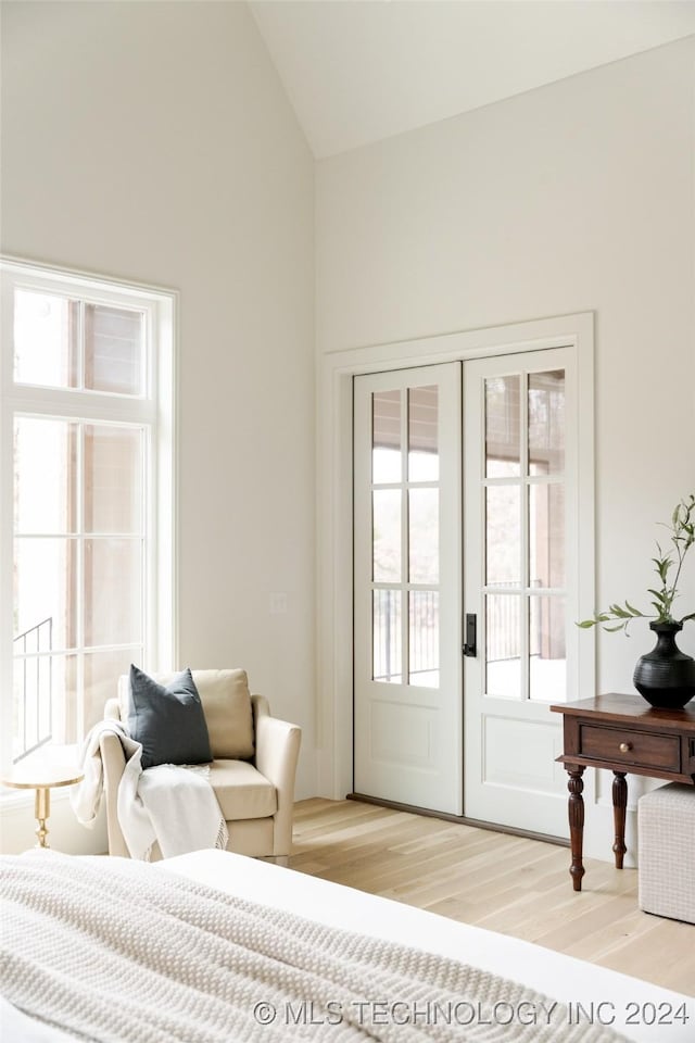 bedroom featuring french doors, multiple windows, and light hardwood / wood-style flooring