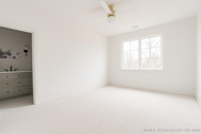 carpeted empty room featuring ceiling fan and sink