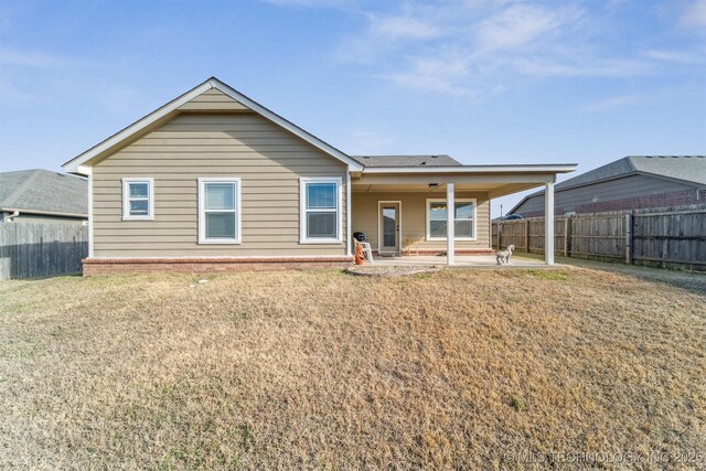 back of house with a patio area and a yard