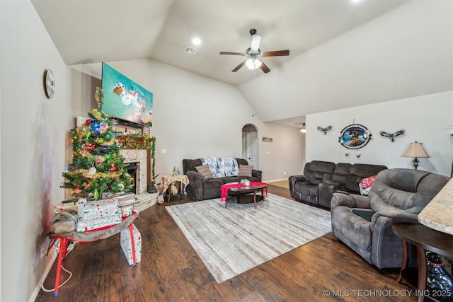 living room with ceiling fan, dark hardwood / wood-style floors, lofted ceiling, and a fireplace