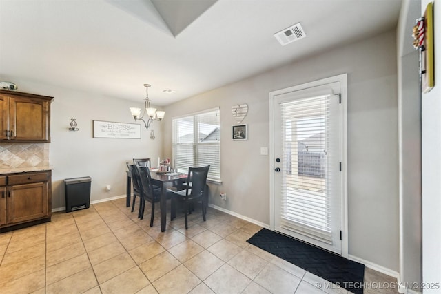 tiled dining room with a chandelier