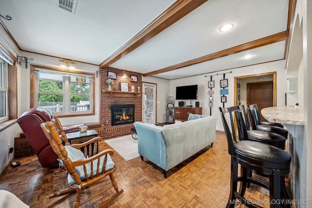 living room featuring beamed ceiling, a brick fireplace, and light parquet flooring