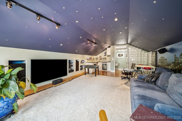 carpeted home theater with track lighting and lofted ceiling