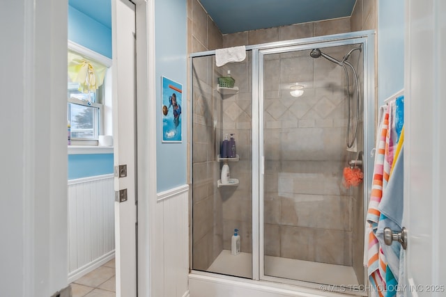 bathroom with tile patterned floors, an enclosed shower, and wooden walls