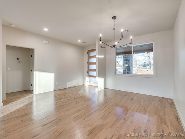 unfurnished dining area featuring recessed lighting, a notable chandelier, light wood-style floors, and visible vents