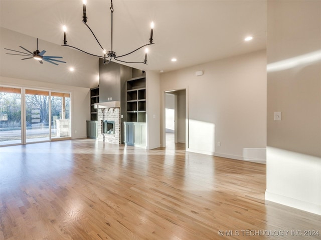 unfurnished living room featuring built in features, light wood finished floors, baseboards, a brick fireplace, and ceiling fan