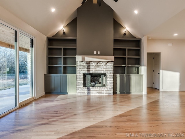 unfurnished living room with high vaulted ceiling, built in features, light wood finished floors, baseboards, and a brick fireplace