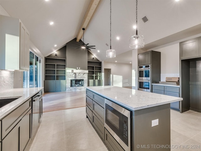 kitchen with light stone counters, visible vents, gray cabinets, appliances with stainless steel finishes, and beamed ceiling