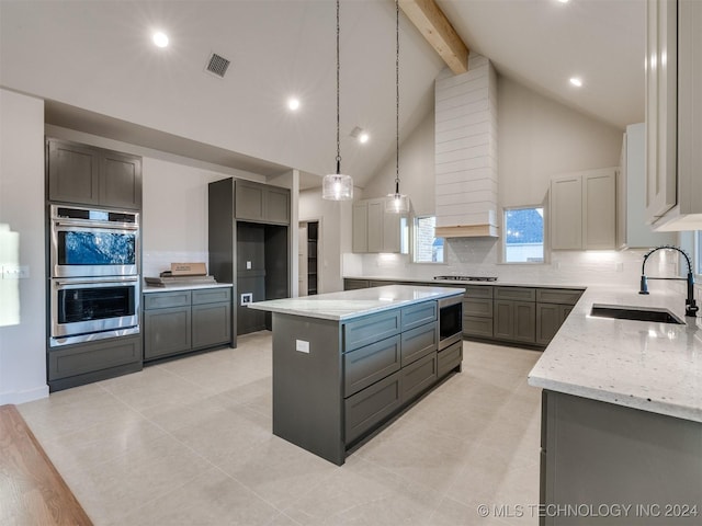 kitchen featuring gray cabinetry, stainless steel appliances, sink, decorative light fixtures, and a kitchen island