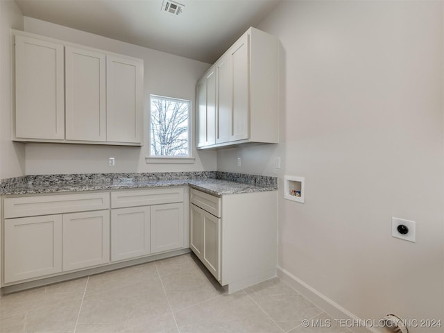 clothes washing area with visible vents, washer hookup, light tile patterned floors, cabinet space, and hookup for an electric dryer