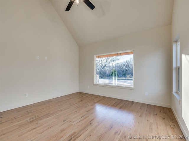 spare room with light wood-type flooring, high vaulted ceiling, and ceiling fan