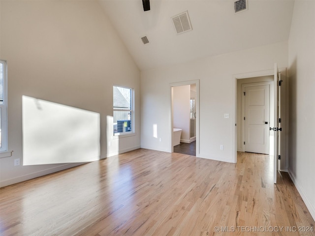 unfurnished bedroom with visible vents, high vaulted ceiling, and light wood finished floors