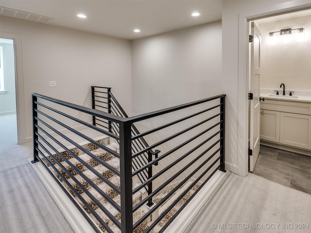 stairs with sink and carpet floors