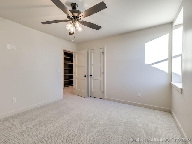 spare room with a healthy amount of sunlight, ceiling fan, and light colored carpet