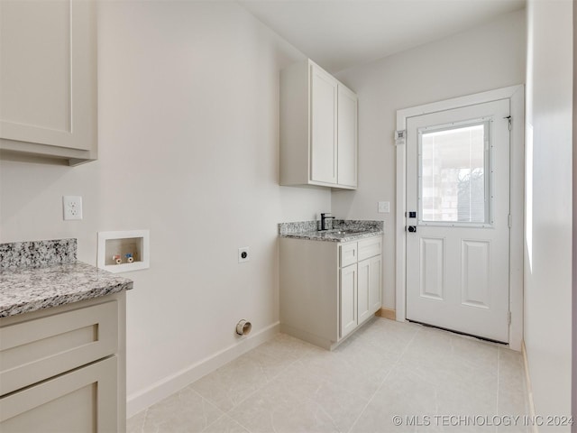 clothes washing area with cabinets, washer hookup, electric dryer hookup, and sink