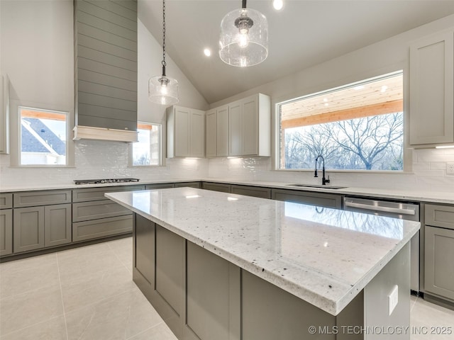 kitchen with gray cabinets, a sink, light stone counters, a center island, and stainless steel appliances