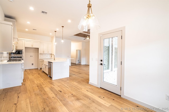 kitchen featuring light countertops, decorative backsplash, a sink, built in microwave, and dishwasher