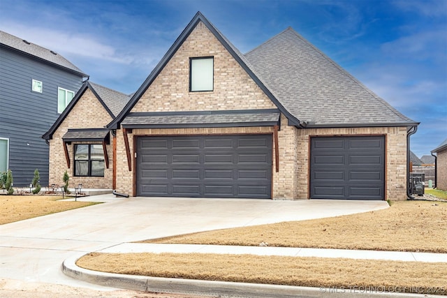 view of front of home with roof with shingles, concrete driveway, and brick siding