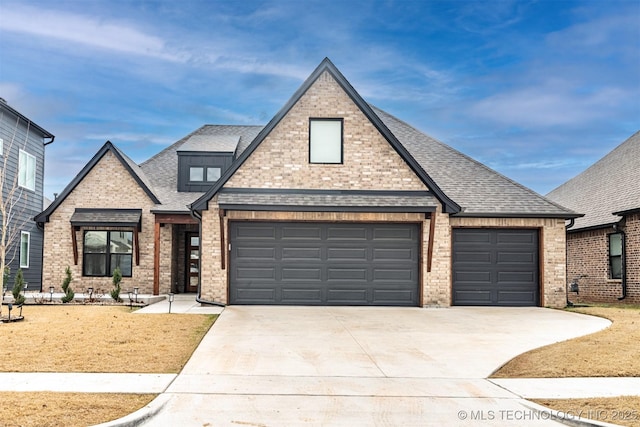 view of front facade with roof with shingles, driveway, brick siding, and an attached garage