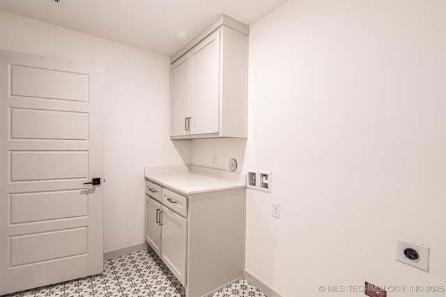 clothes washing area featuring hookup for a washing machine, hookup for an electric dryer, baseboards, cabinet space, and light floors