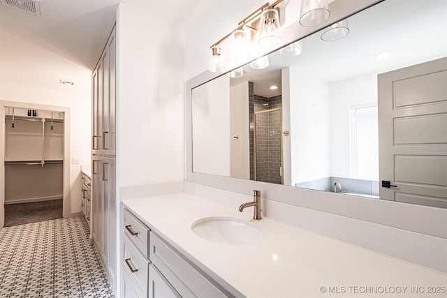 full bath with a shower stall, visible vents, baseboards, and vanity