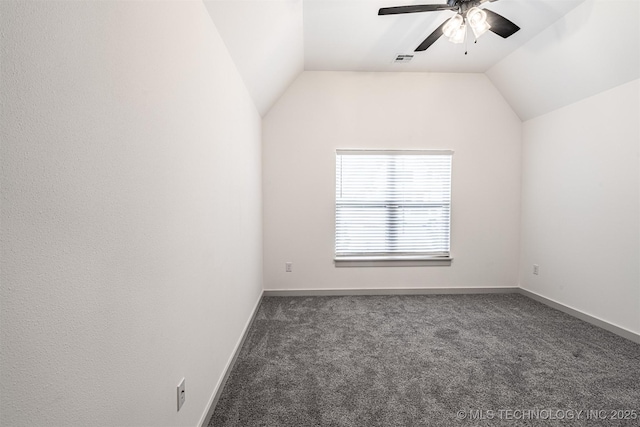 carpeted empty room featuring ceiling fan, visible vents, baseboards, and vaulted ceiling