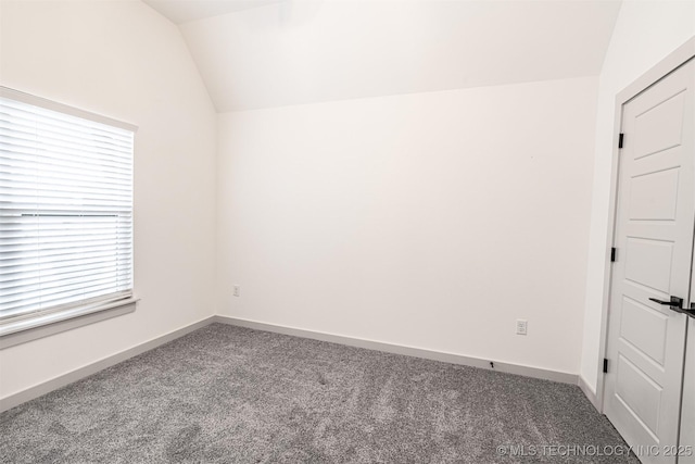 unfurnished room featuring vaulted ceiling, carpet floors, and baseboards