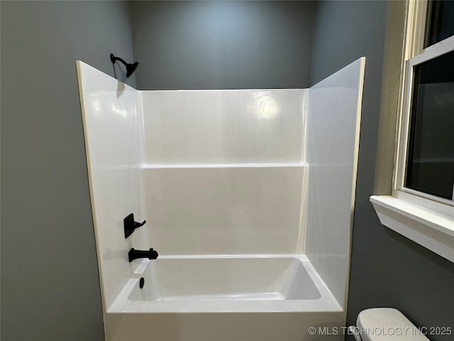 bathroom featuring  shower combination and toilet