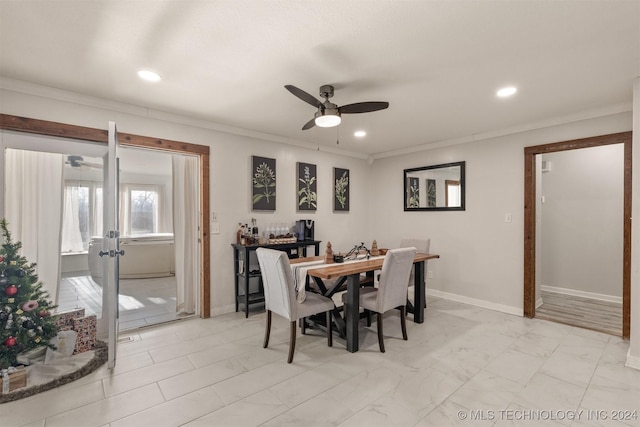 dining space featuring ceiling fan and ornamental molding