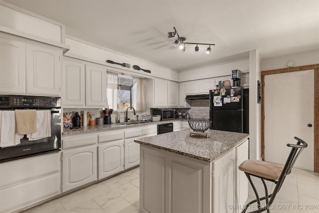 kitchen with sink, white cabinetry, a kitchen island, and black appliances