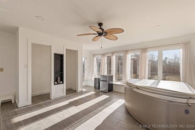 unfurnished sunroom with ceiling fan