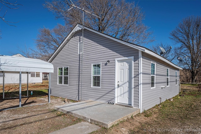 back of property with a carport