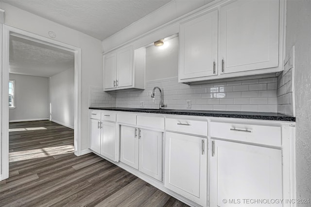 kitchen featuring a textured ceiling, white cabinetry, and sink