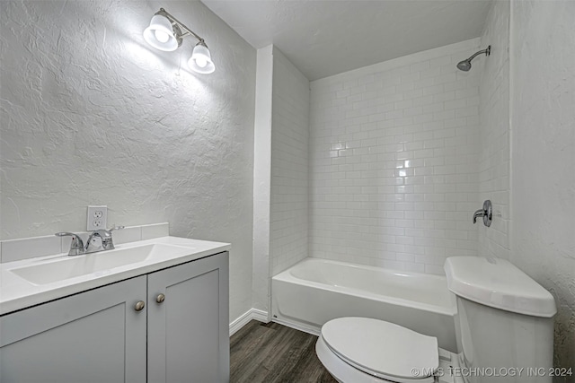 full bathroom featuring hardwood / wood-style floors, vanity, toilet, and tiled shower / bath combo