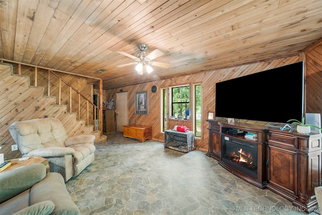 living room featuring ceiling fan, wood walls, and wood ceiling