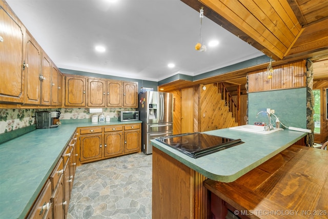 kitchen featuring pendant lighting, stainless steel appliances, a kitchen breakfast bar, and sink