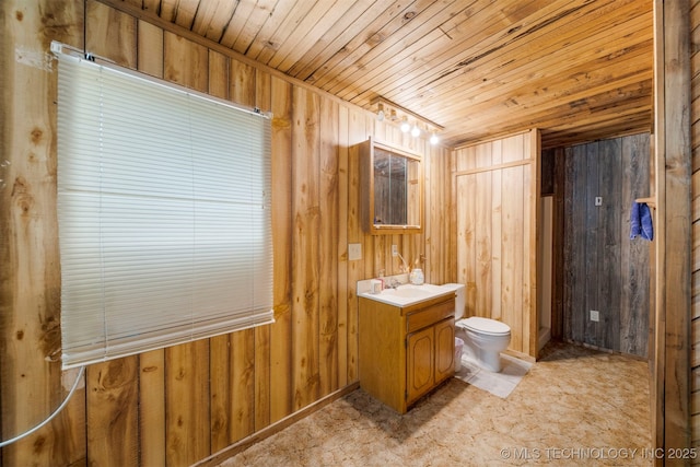 bathroom with vanity, toilet, wood ceiling, and wooden walls