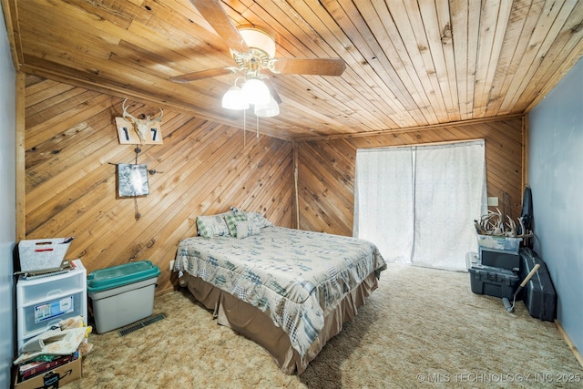 carpeted bedroom with ceiling fan, wooden walls, and wood ceiling