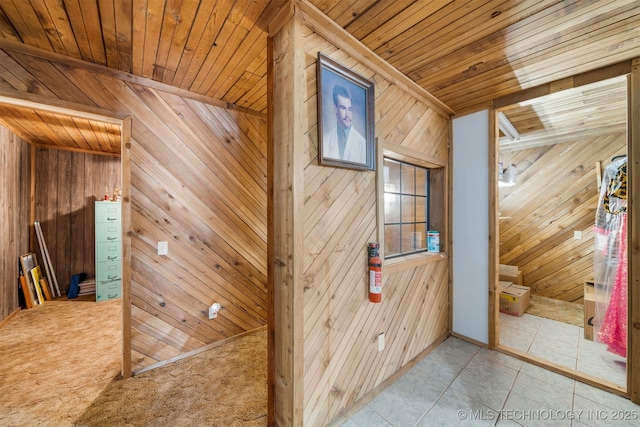 hall featuring wood walls, carpet, and wood ceiling