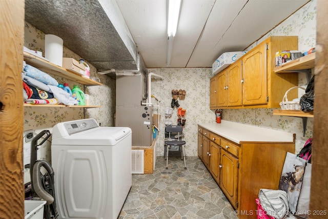 clothes washing area featuring cabinets, washer / clothes dryer, and heating unit